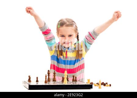 Adorable fille d'âge scolaire se sent extrêmement heureux de gagner dedans échecs isolés sur fond blanc Banque D'Images