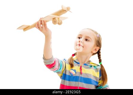 Belle fille souriante jouant avec l'ancien avion de jouet en bois isolé sur fond blanc Banque D'Images