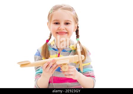 Belle fille souriante jouant avec l'ancien avion de jouet en bois isolé sur fond blanc Banque D'Images