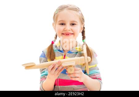 Belle fille souriante jouant avec l'ancien avion de jouet en bois isolé sur fond blanc Banque D'Images