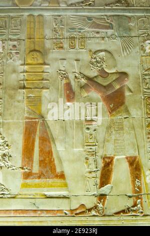 Ancien bas relief égyptien montrant Pharaon Seti I faisant une offrande à la colonne sacrée Djed. Intérieur du temple Abydos, el Balyana, Égypte. Ancien Banque D'Images