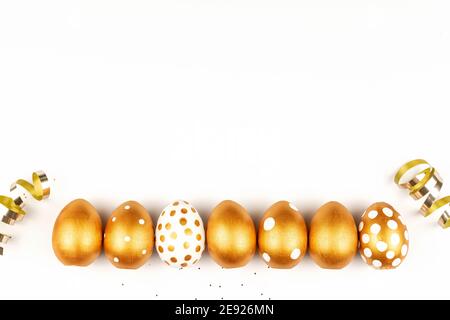 Décoration de fête de Pâques. Vue du dessus des œufs de pâques colorés avec de la peinture dorée sur fond blanc. Divers motifs en pointillés. Banque D'Images