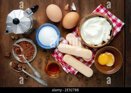 Dessert italien Tiramisu ingrédients de gâteau au-dessus de la vue sur sombre rustique arrière-plan en bois Banque D'Images