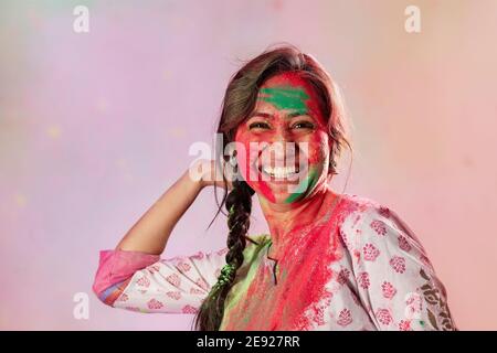 Femme jetant le gulal à l'occasion de Holi Banque D'Images