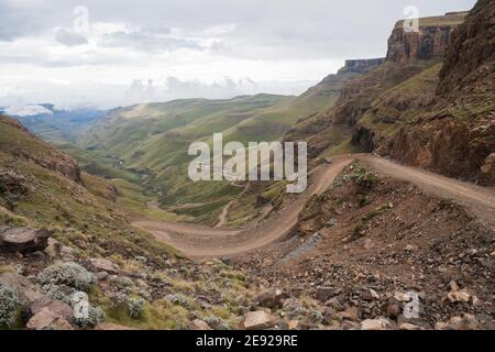 Route de montagne sinueuse abrupte de Sani Pass entre l'Afrique du Sud Et le Royaume du Lesotho contrôle les frontières sous ciel nuageux Banque D'Images