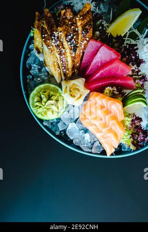 Différents types de (ebi, saké, unagi, maguro) sashimi sur glace dans un bol dans un restaurant Banque D'Images