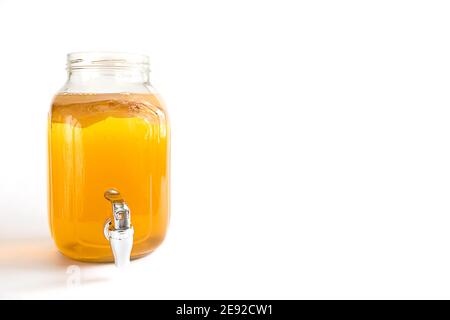 Kombucha-une boisson à base de champignons du thé dans un pot en verre avec robinet. Tasse transparente avec une boisson à base de levure à base de champignons japonais-méduse. Blanc b Banque D'Images