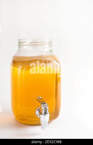 Kombucha-une boisson à base de champignons du thé dans un pot en verre avec robinet. Tasse transparente avec une boisson à base de levure à base de champignons japonais-méduse. Blanc b Banque D'Images