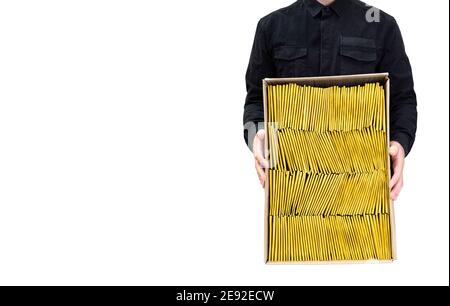 Grande boîte d'expédition ouverte pleine d'enveloppes à bulles rembourrées tenues par un homme en uniforme noir isolé sur blanc. Studio shot, espace de copie. Banque D'Images