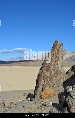 Le Grandstand sur l'hippodrome Playa dans le parc national de la Vallée de la mort, un rocher gris très foncé entouré de sédiments argileux et légers Banque D'Images