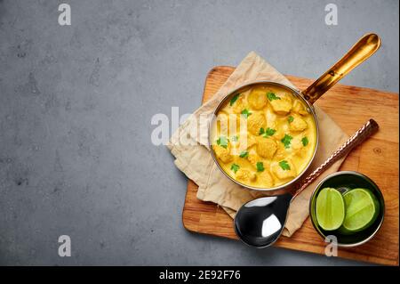 Poulet Korma dans un récipient en cuivre sur une table en béton gris. Cuisine indienne plat de cari à la viande avec masala au lait de coco. Cuisine asiatique. Copier l'espace Banque D'Images