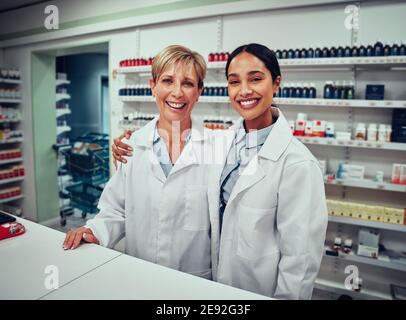 Portrait d'une jeune pharmacienne heureuse avec un collègue senior souriant à l'appareil photo Banque D'Images