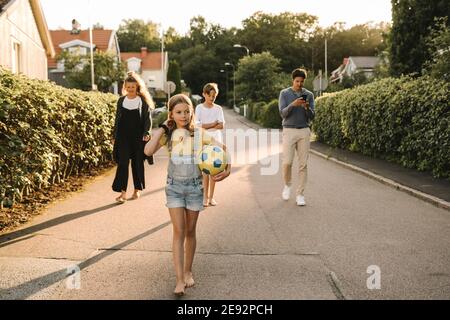 Enfants marchant avec leurs parents sur la route Banque D'Images