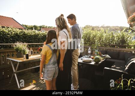 Mère et père avec fille debout sur le balcon Banque D'Images