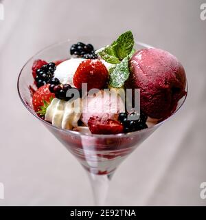 Glace servant dans une verrerie avec différentes baies Banque D'Images