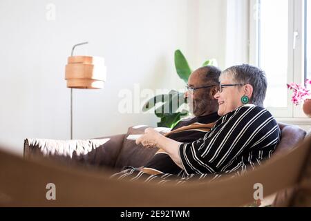 Couple heureux regardant la télévision dans le salon Banque D'Images