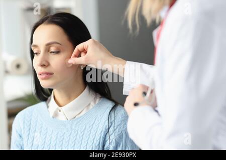 Médecin collant le plâtre adhésif sur le visage du patient Banque D'Images