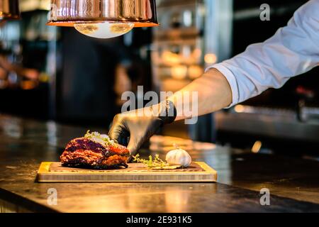Chef cuisinant des côtes grillées sur un comptoir dans un restaurant Banque D'Images