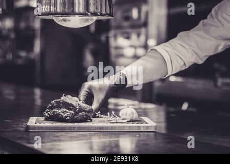 Chef cuisinant des côtes grillées sur un comptoir dans un restaurant Banque D'Images