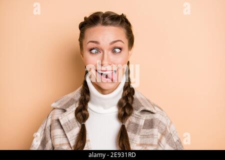 Portrait de belle coiffure puildish personne qui s'accroupille les yeux langue dehors porter un tissu écossais isolé sur un arrière-plan beige Banque D'Images