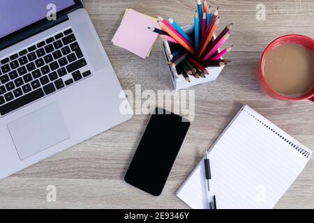 Bureau de travail avec crayons pour ordinateur portable et une tasse de café Banque D'Images