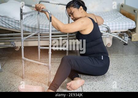 Dame asiatique femme d'âge moyen chute du patient dans la salle de séjour parce que les surfaces glissantes Banque D'Images