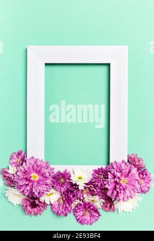 Composition des fleurs. Cadre photo vide et fleurs sur fond vert pastel. Saint-Valentin, Fête des mères, Fête des femmes, concept de printemps. Plat, dessus Banque D'Images