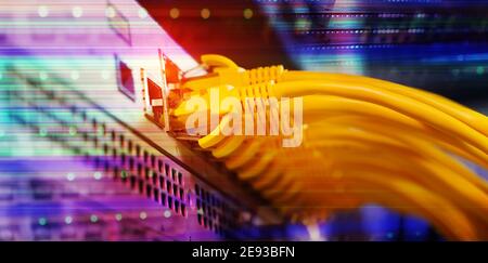 Rack serveur bleu et rouge avec cordon de raccordement internet câbles connectés au panneau de raccordement noir dans la salle des serveurs de données Banque D'Images