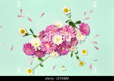 Composition des fleurs. Mise en page créative avec fleurs blanches et violettes sur fond vert pastel. Pose à plat. Concept de printemps minimal. Banque D'Images