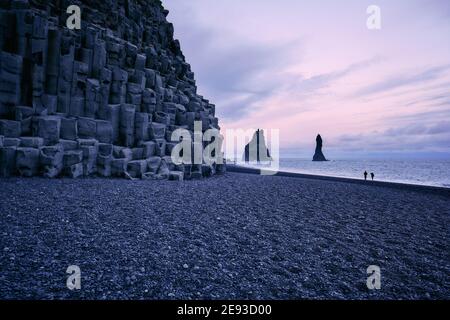 La plage de sable noir de lave de Reynisfjara et de Reynisdrangar La mer de basalte s'empile au crépuscule sur la côte sud de l'Islande - paysage de basalte d'Islande Banque D'Images