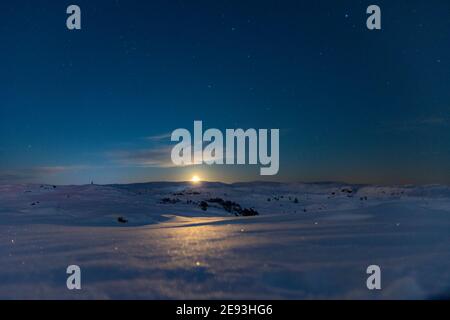 Une belle image de lune entourée d'étoiles prises sur le mont Rundemanen à Bergen, Norvège. Banque D'Images