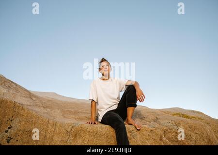 Woman sitting on rock Banque D'Images