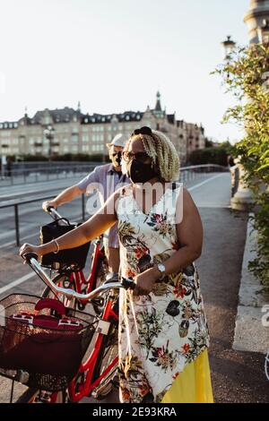 Homme et femme âgés qui se sont mis à vélo sur le pont pendant une pandémie Banque D'Images