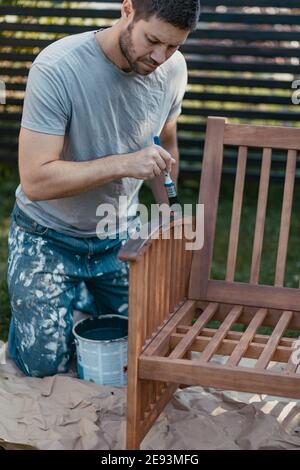 Banc de peinture homme dans le jardin Banque D'Images