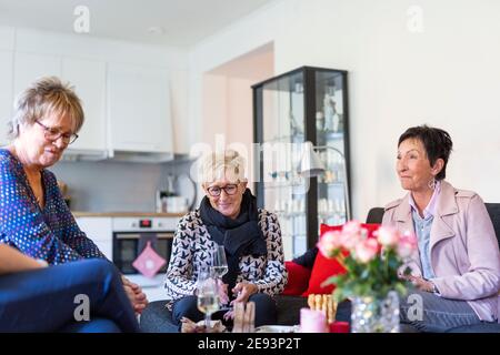 Groupe de femmes âgées qui boivent du champagne à la maison Banque D'Images