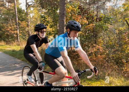 Une femme malvoyée s'entraîne avec elle sur un vélo tandem guide et autocar Banque D'Images