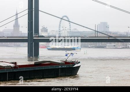 Inonder le Rhin à Düsseldorf - vue sur le pont Rheinkniebrucke, la vieille ville avec l'église Lambertus, la tour du château et la grande roue Banque D'Images