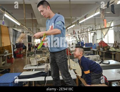 (210202) -- FUZHOU, 2 février 2021 (Xinhua) -- Congcong interagit avec son père Huang Hailong dans une usine de vêtements à Shishi, dans la province de Fujian, dans le sud-est de la Chine, le 26 janvier 2021. Suite à la résurgence sporadique des cas de COVID-19, de nombreux endroits en Chine ont encouragé les résidents et les travailleurs migrants à rester mis en place pour célébrer le Festival du printemps, pour réduire le flux de personnel et freiner la propagation du coronavirus pendant la période des fêtes. Huang Hailong, un travailleur migrant de Shishi, a déclaré que ce serait sa première fois au cours des dernières années de passer les vacances à Shishi au lieu de sa ville natale dans le Cit Banque D'Images