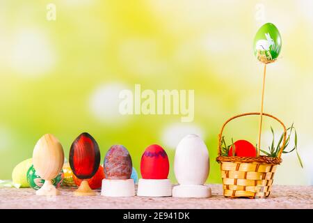 Vacances de printemps. Composition colorée de Pâques sur fond artistique vert. Œufs décoratifs peints et un petit panier avec de l'herbe fraîche. Pâques Banque D'Images
