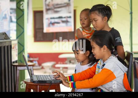 Laos, Don Dhet. Vue horizontale d'un groupe de filles prenant une leçon à travers un ordinateur portable. Banque D'Images