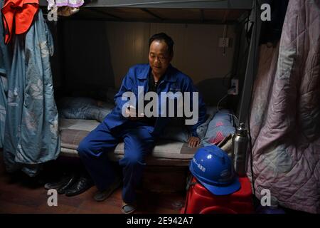 (210202) -- FUZHOU, 2 février 2021 (Xinhua) -- du Xuegang a un chat vidéo avec sa famille dans son dortoir de Putian, dans la province du Fujian du sud-est de la Chine, le 28 janvier 2021. Suite à la résurgence sporadique des cas de COVID-19, de nombreux endroits en Chine ont encouragé les résidents et les travailleurs migrants à rester mis en place pour célébrer le Festival du printemps, pour réduire le flux de personnel et freiner la propagation du coronavirus pendant la période des fêtes. L'homme de 51 ans du Xuegang, originaire de la province de Henan, travaille avec ses collègues dans la cour de fabrication de la poutre du chantier de construction de Fuzhou-Xiame Banque D'Images