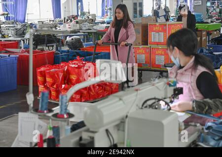 (210202) -- FUZHOU, le 2 février 2021 (Xinhua) -- UN membre du personnel tire un chariot chargé de trousses-cadeaux du nouvel an préparées pour le personnel de Wellgreen Outdoor Co., Ltd. Dans le comté de Minhou, Fuzhou, dans la province de Fujian, dans le sud-est de la Chine, le 1er février 2021. Suite à la résurgence sporadique des cas de COVID-19, de nombreux endroits en Chine ont encouragé les résidents et les travailleurs migrants à rester mis en place pour célébrer le Festival du printemps, pour réduire le flux de personnel et freiner la propagation du coronavirus pendant la période des fêtes. Dans le comté de Minhou à Fuzhou, dans la province de Fujian, une usine d'équipement de plein air a offert le Ki du nouvel an Banque D'Images