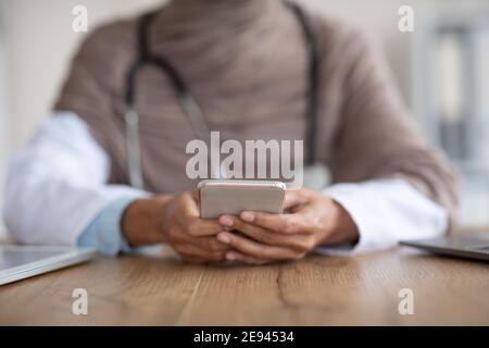Culture d'une femme médecin avec un smartphone en clinique Banque D'Images