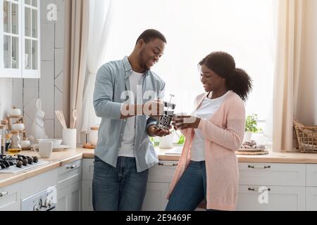 La vie quotidienne du couple. Happy Black conjoints boire du café dans une cuisine confortable Banque D'Images