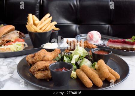 Sheffield, Royaume-Uni - 03 août 2017 : poulet frit du sud, bâtonnets de mozzarella en commun, cheeseburger, frites et cheesecake à OHM, Fitzwilliam Street Banque D'Images