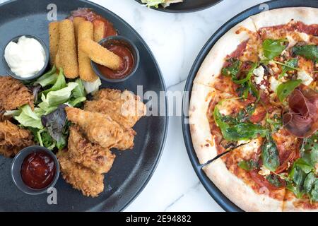 Sheffield, Royaume-Uni - 03 août 2017 : poulet frit du sud, plateau de lancement de bâtonnets de mozarella et pizza au salami et à la roquette Peperoni à OHM, Fitzwilliam Street Banque D'Images