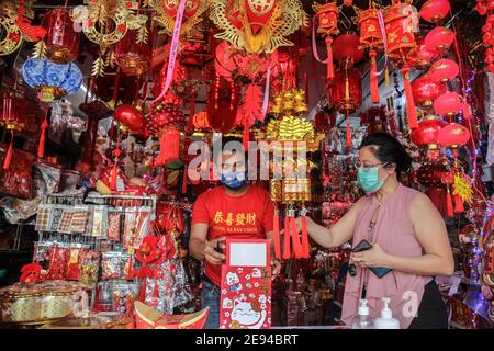 Medan, Sumatra Nord, Indonésie. 2 février 2021. Les acheteurs utilisent des masques pour chercher des décorations du nouvel an lunaire dans des stands installés dans un magasin de Medan, dans le nord de Sumatra, avant le nouvel an lunaire de l'Ox, dans le contexte de l'épidémie de Covid-19, le 12 février, en Indonésie. Crédit: Albert Ivan Damanik/ZUMA Wire/Alay Live News Banque D'Images