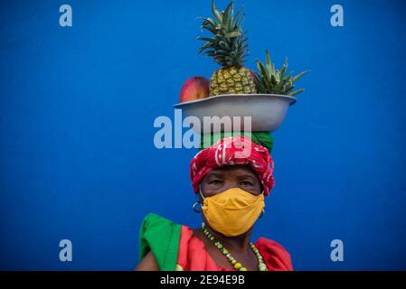 Cartagena, Colombie février 2021: Femmes vendeurs de fruits vendeurs de fruits femme nommée Palenquera portant un masque facial pendant le voyage pandémique COVID 19 Banque D'Images