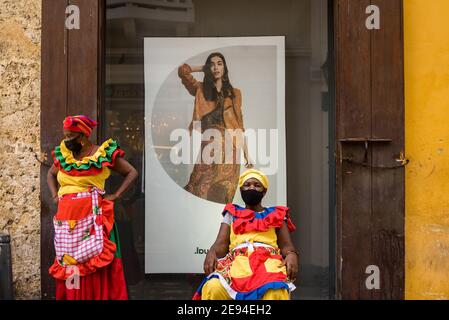 Cartagena, Colombie février 2021: Femmes vendeurs de fruits vendeurs de fruits femme nommée Palenquera portant un masque facial pendant le voyage pandémique COVID 19 Banque D'Images