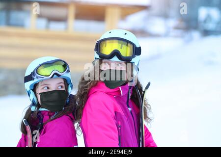 les jeunes sœurs s'amusent sur la piste de ski en casques et masques sur le visage Banque D'Images